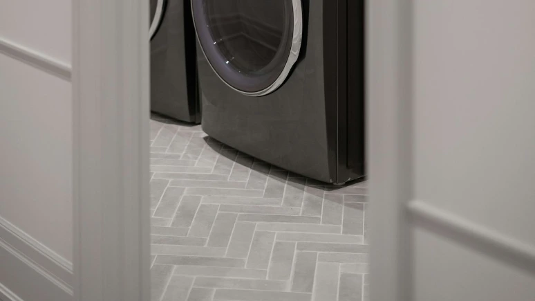 Modern laundry room with gray washer and dryer.